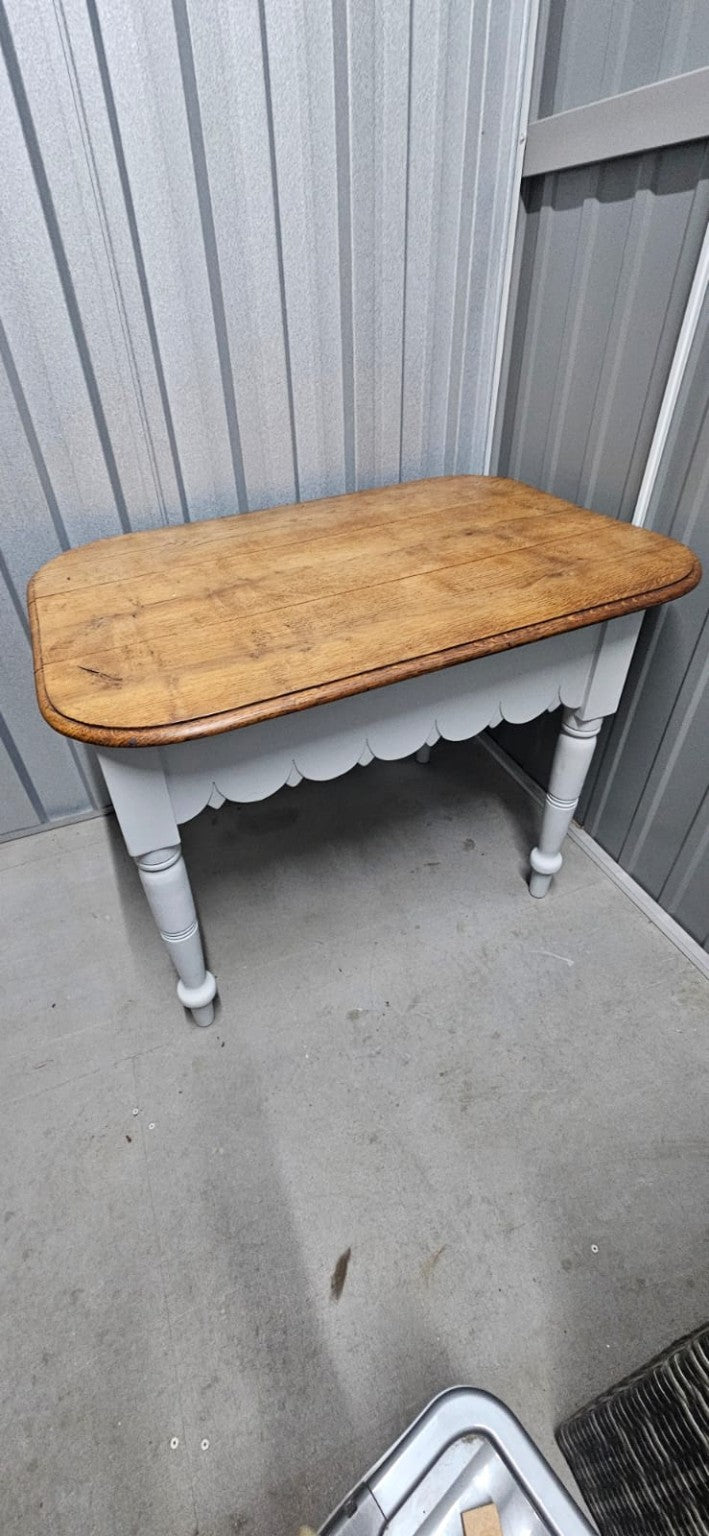Actual farmhouse-style painted small wooden kitchen table with natural wood-look top