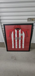 Full view of Southampton FC multi-signed shirt in its original black frame