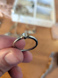 Silver-colour unmarked solitaire ring with round clear stone