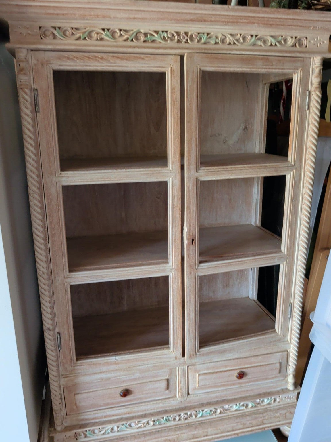 Actual ornate distressed cream display cabinet with two tall doors and two lower drawers
