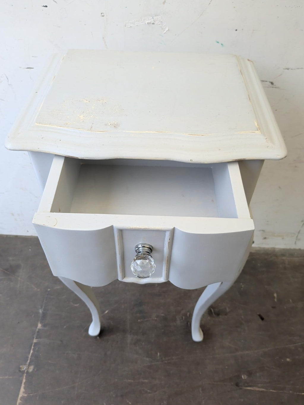 Actual bedside table with drawer open showing storage