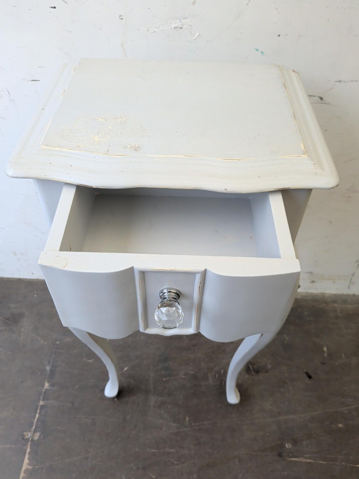 Actual bedside table with drawer open showing storage