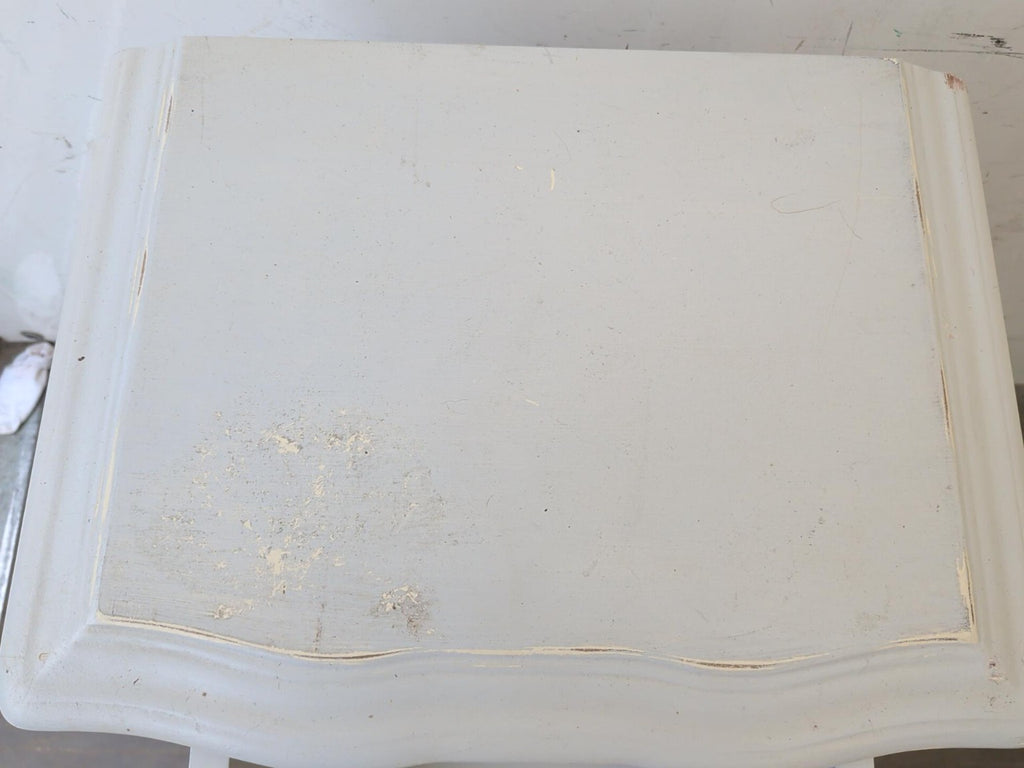 Actual bedside table top showing marks and paint wear