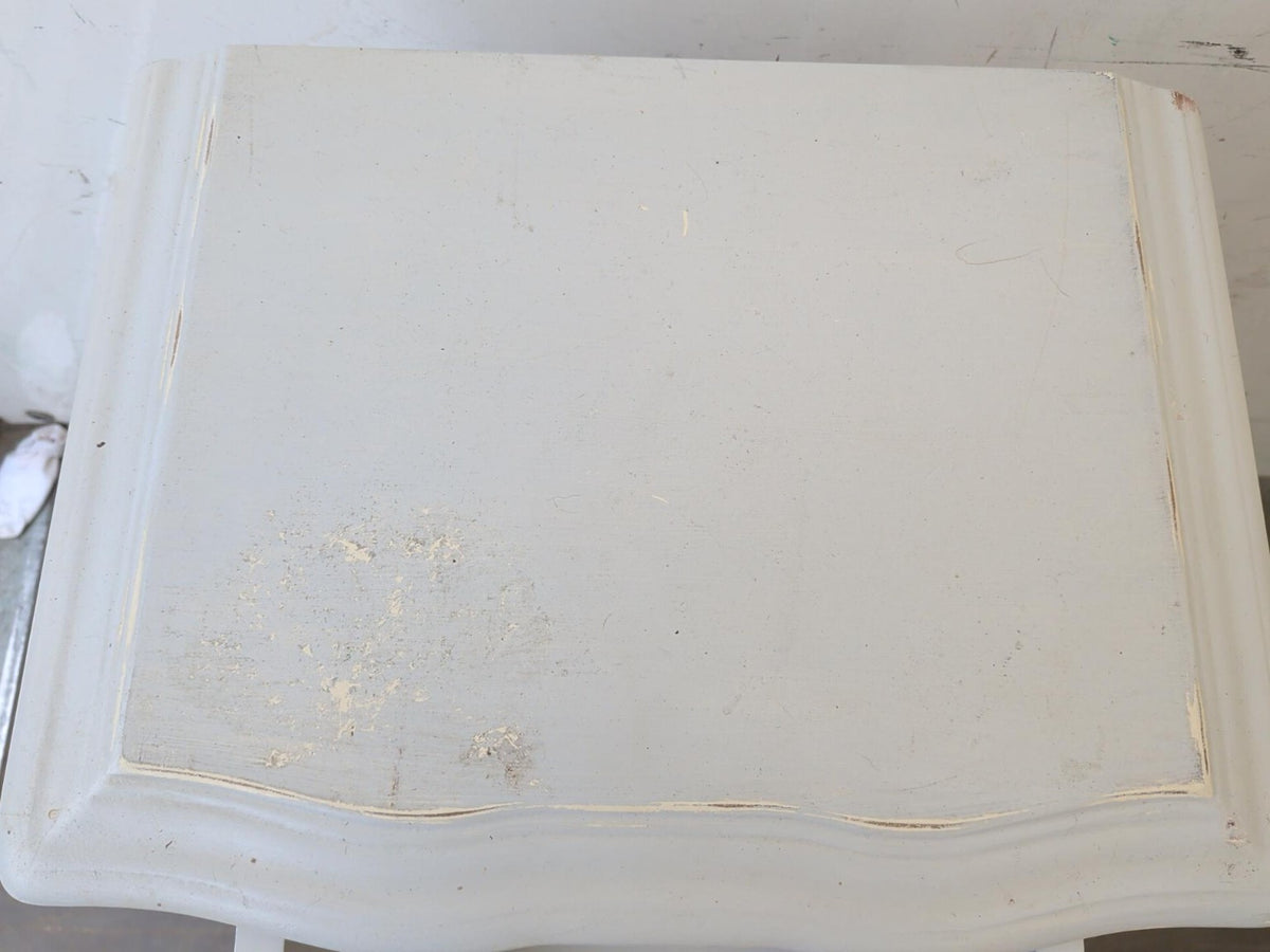 Actual bedside table top showing marks and paint wear