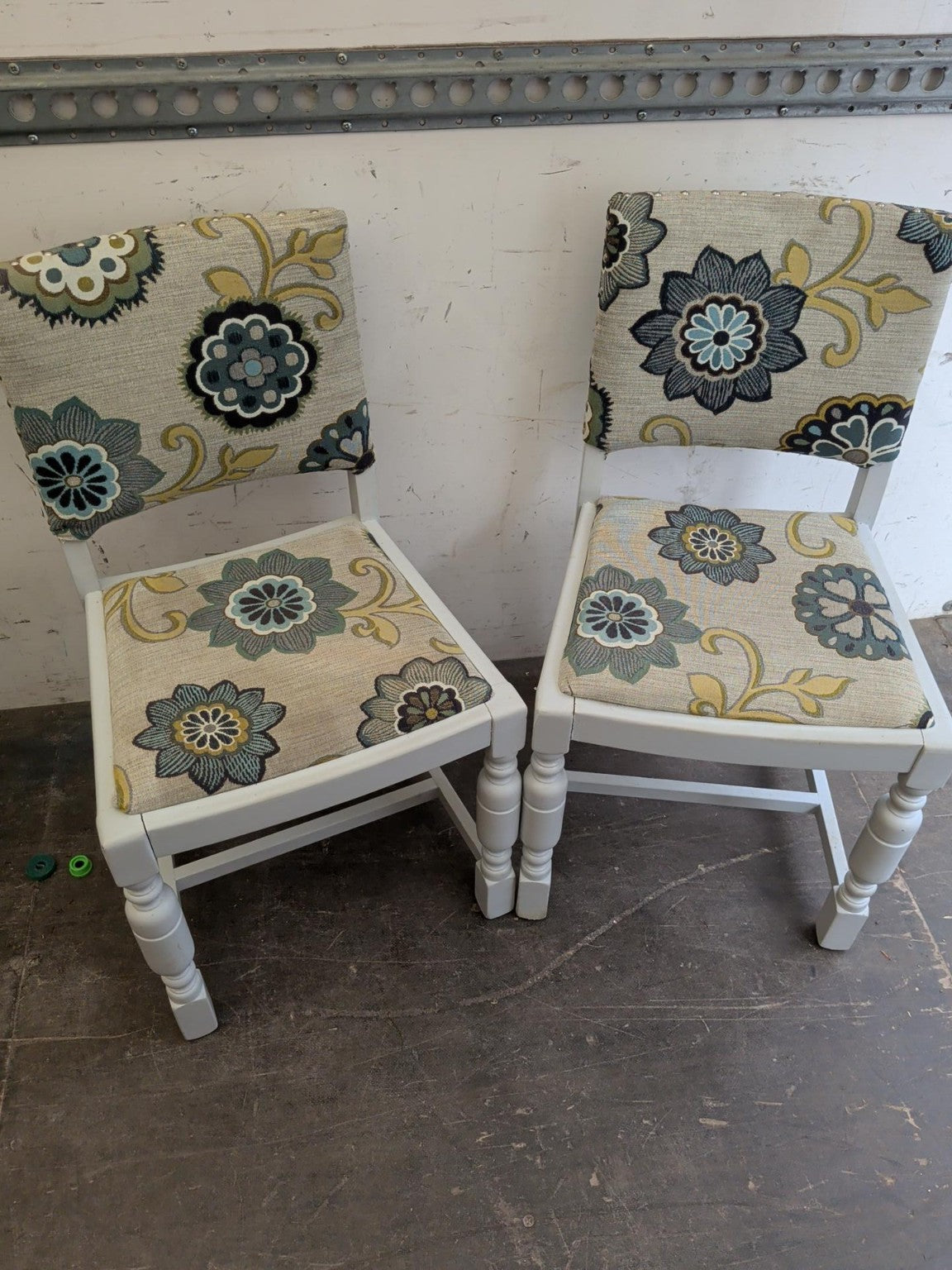 Actual matching pair of white painted floral upholstered dining chairs included in the set