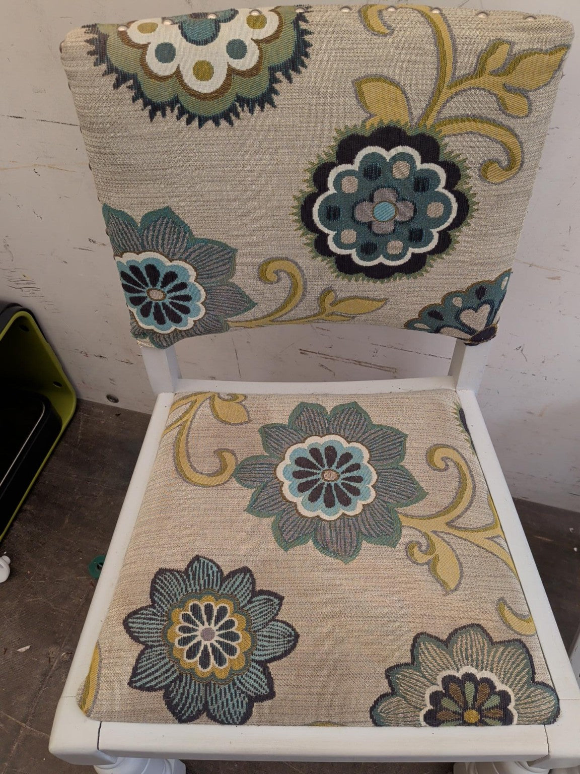 Actual first floral upholstered chair with visible finish wear