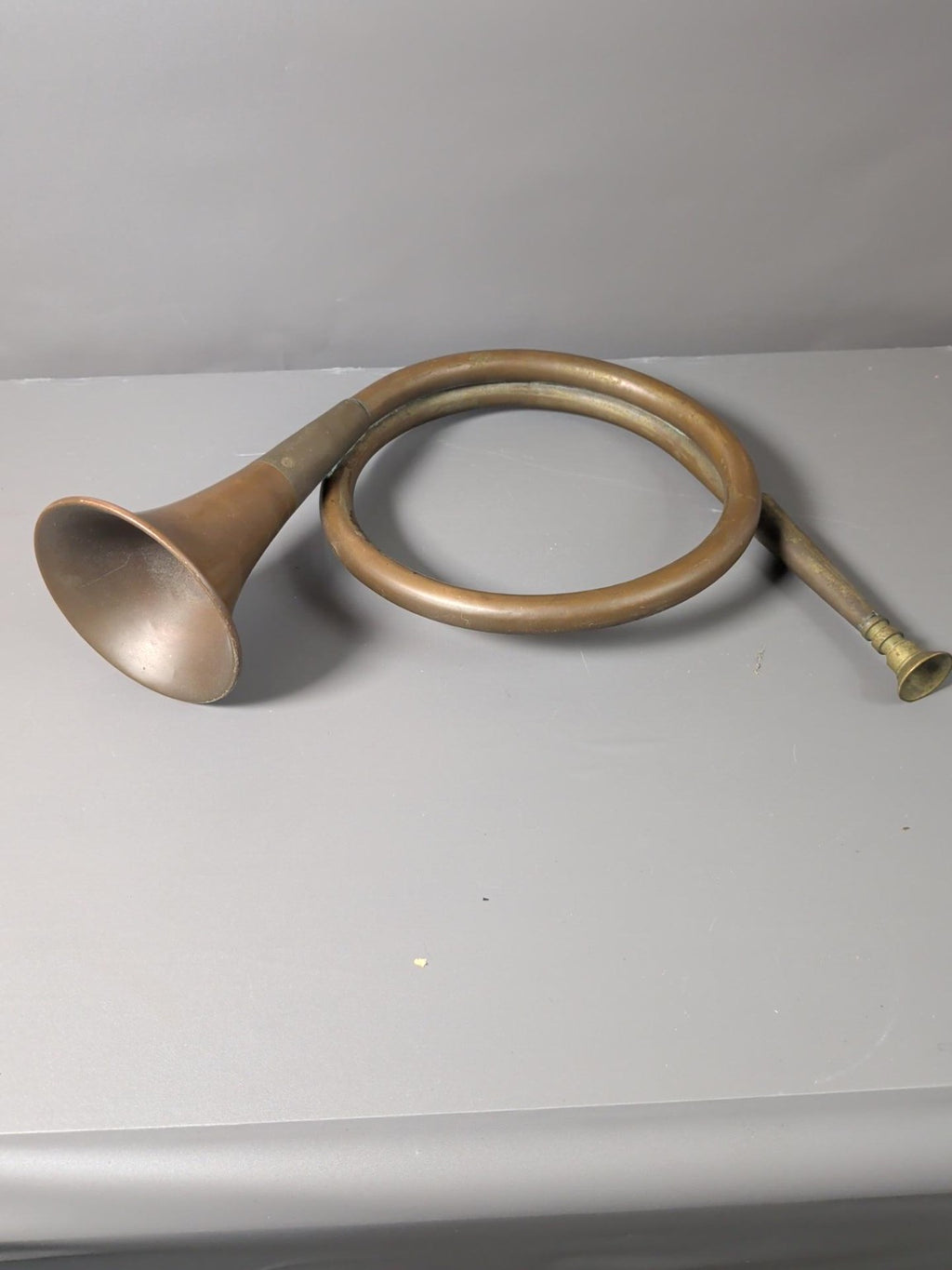 Vintage coiled hunting coach horn showing bell and mouthpiece