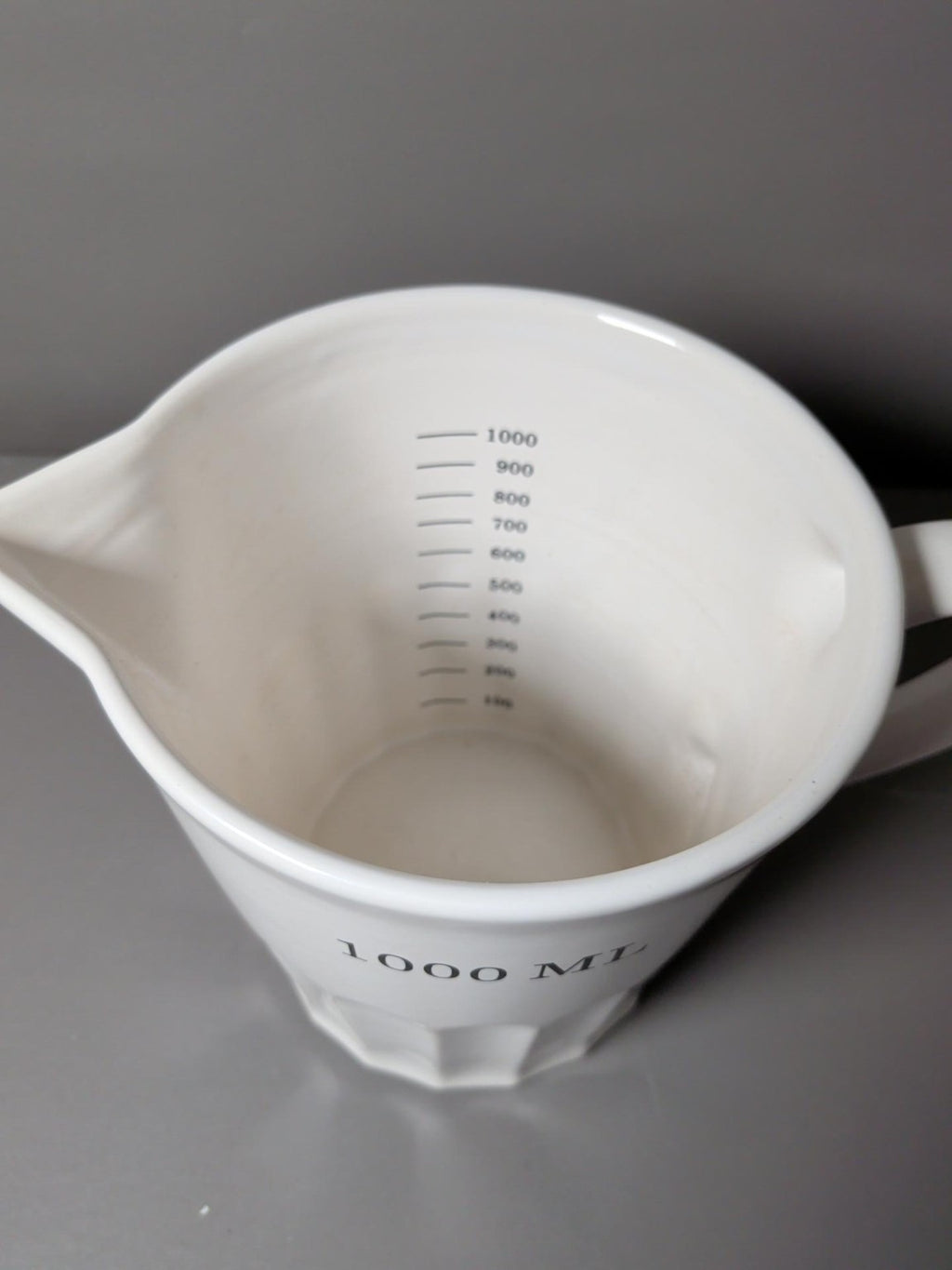 Internal 100ml measurement graduations inside white ceramic measuring jug